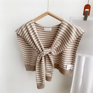 Close-up of brown and white striped knitted shawl with decorative front tie detail