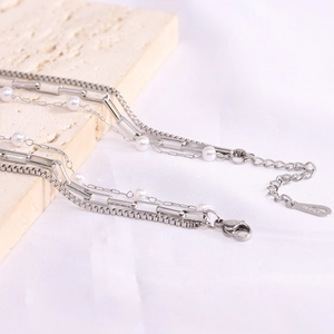 Detailed macro of silver-tone multi-layer chain necklace with pearls and 14KGP lobster clasp
