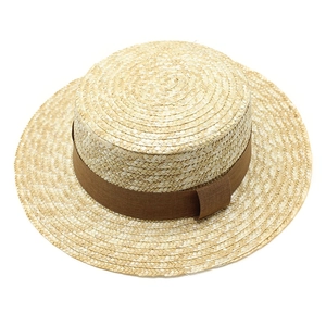 Close-up of a hand-woven boater hat featuring natural straw texture and a brown ribbon band