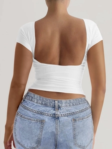 Détail d'un t-shirt blanc moulant à manches courtes avec un décolleté sexy dans le dos