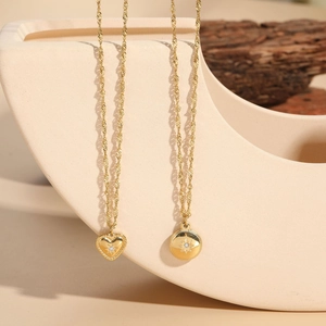 Detail of gold starburst heart and coin pendants with crystals on dainty water wave chains