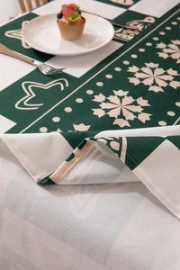 Detail of green snowflake Christmas tablecloth corner showing durable fabric texture