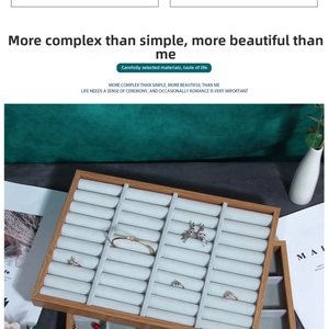 Detail of bamboo jewelry display tray with grey velvet slots for rings and bangles