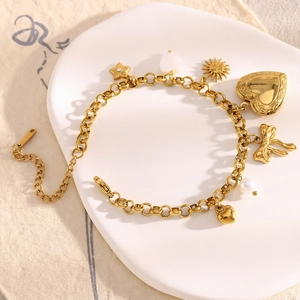 Detailed macro of 18K gold plated stainless steel bracelet with heart and star charms