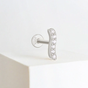 Macro shot of S925 sterling silver stamp on the back of a curved diamond-set stud earring
