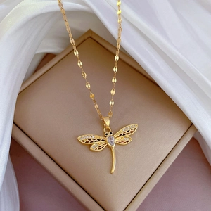 Luxurious gold dragonfly pendant necklace with zircon inlays on an elegant silk display