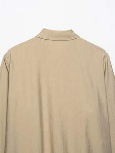 Detailed close-up of khaki shirt collar and back shoulder stitching with twill texture