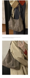 Detail view of khaki suede tote bag with decorative side zippers and metal hardware