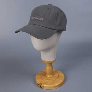 Close-up of pink 'BONNE CHANCE' embroidery on a dark grey cotton baseball cap