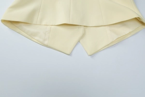 Close-up detail showing the fine stitching and woven fabric texture of the cream blazer