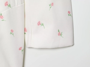 Nahaufnahme von leichtem weißem Stoff mit elegantem rosa Blumenmuster für Sommer-Blazer