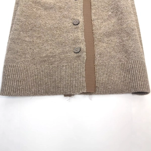 Brown off-shoulder knit cardigan with dark round buttons and ribbed hem details
