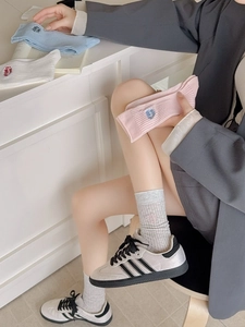Detail of embroidered letters on soft breathable cotton crew socks in pastel colors