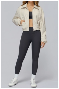 Detail of beige windproof sports jacket with elastic cuffs and a minimalist zipper design