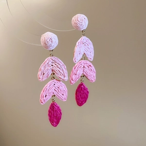 Detail of pink gradient raffia tassel earrings with handmade bohemian woven texture