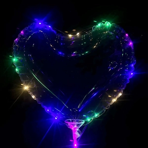 Macro detail of heart-shaped transparent LED balloon with colorful lights on black background
