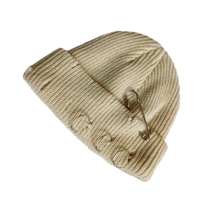 Close-up of knit beanie with metal rings and decorative safety pin detail