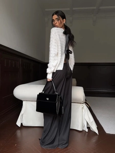 Elegant white hollow knit sweater with black back ribbon bow and wide-leg trousers