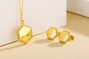 Detailed view of golden hexagonal jewelry set with beaded edges and polished surface