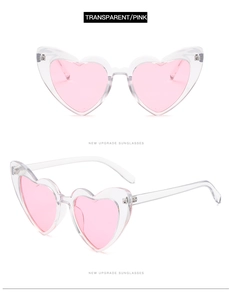Macro detail of transparent pink heart sunglasses showing metal hinges and sleek temples