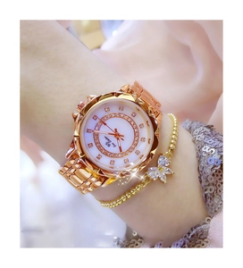 Detail of gold rhinestone watch with flower mother-of-pearl dial and bow bracelet