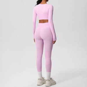Rear view of pink long sleeve yoga set featuring high waist leggings and backless detail