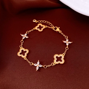 Close-up of 24K gold plated hollow flower bracelet with marquise-cut crystals on brown fabric