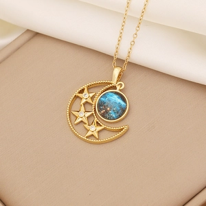 Detailed close-up of a golden moon and star pendant necklace with a blue nebula gemstone
