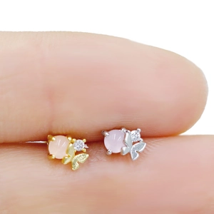 Détail macro de boucles d'oreilles papillon avec perles roses et zircons cubiques