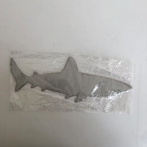 Detailed view of silver shark steel wall art decoration in protective packaging