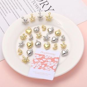Close-up of gold and silver plated heart, star, and moon charms with inlaid rhinestones