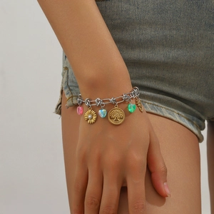 Detail view of multi-element charm bracelet with colorful resin hearts and gold pendants