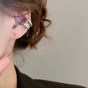 Detail of silver double-layered metal ear cuff with textured and smooth ring design