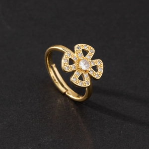 Close-up of golden floral ring with heart-shaped petals and zircon stone inlay