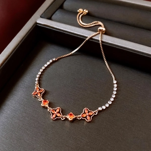 Detail of 18K gold plated floral bracelet with orange gemstones and adjustable slider clasp