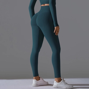 Detail of high-waisted seamless yoga leggings and long sleeve top in dark green