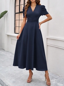 Detail view of navy blue V-neck dress featuring subtle stripes and cinched waistline