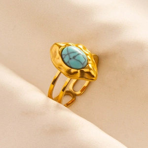 Detailed view of adjustable gold ring with turquoise stone and hammered texture