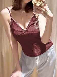 Detail of burgundy polka dot camisole with white trim and grey striped lounge pants