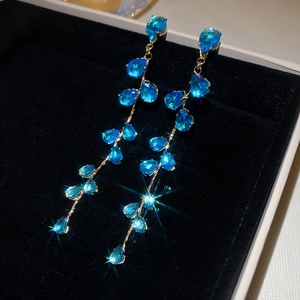 Detail of blue teardrop zircon tassel earrings on black velvet gift jewelry box