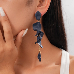 Detailed shot of dark blue acrylic petal tassel earrings worn by a fashion model