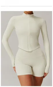 Detail einer schmal geschnittenen, cremefarbenen Yoga-Jacke mit Reißverschluss und Stehkragen