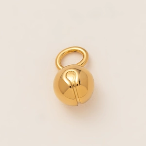 Gros plan d'un pendentif cloche plaqué or 18 carats avec surface métallique polie