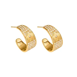 Detailed view of gold C-shaped stainless steel floral earrings with zircon stones