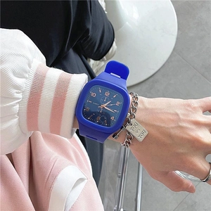 Detailed shot of a girl wearing a square blue silicone sports watch with a metal bracelet