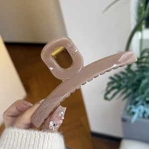 Close-up of large pink rectangular matte hair claw clip with strong gold metal spring