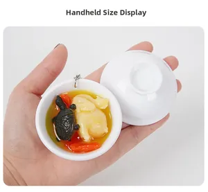 Portachiavi di cibo in miniatura tenuto in mano che mostra il modello di zuppa di pollo