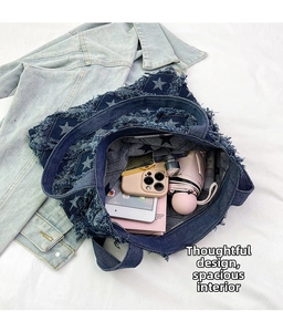 Deep blue denim tote bag with star print and fringe showing spacious inner storage
