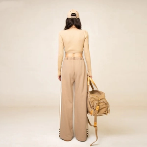 Vue arrière du pantalon large beige avec doubles rayures et haut ajusté à manches longues