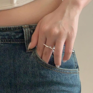 Close-up of minimalist sterling silver knotted ring worn on index finger for daily style